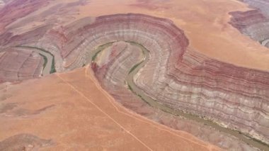 San Juan, Utah 'taki San Juan Kanyonu' nun engebeli arazilerini oyan sarmal Rio San Juan 'ın üst hava manzarası. Nehrin canlı rengi yıpranmış kanyon duvarlarıyla keskin bir tezat oluşturuyor..