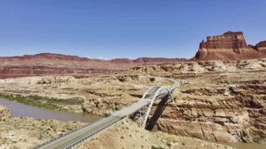 ABD 'nin Glen Canyon Ulusal Rekreasyon Bölgesi' nde yer alan ve Beyaz Kanyon 'un kurak manzarası arasında Colorado Nehri' ni kapsayan bir köprüyü gösteren panoramik bir manzara