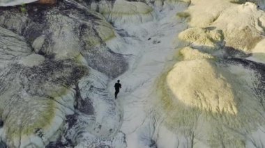 Hava görüntüsü, Bisti Çorak Toprakları 'nın dramatik ve dokulu arazisinde yürüyen yalnız bir kâşifin eşsiz jeolojik özelliklerini gösteriyor.