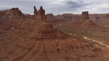 Utah 'ın kasvetli, bulutlu bir gökyüzü altında rutubetli ve görkemli manzaraları jeolojik harikalar ve kasvetli bir atmosferde engebeli araziler sergiliyor.