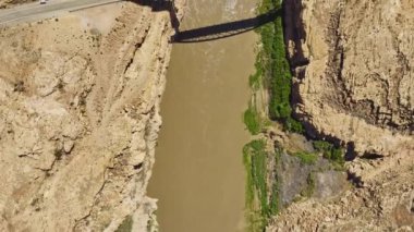 ABD 'deki Glen Kanyonu Ulusal Eğlence Bölgesi' nin bir parçası olan Beyaz Kanyon 'un kayalık manzaraları içinde yer alan Colorado Nehri' nden geçen bir köprüyü çeken çarpıcı bir hava görüntüsü.