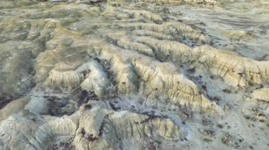Bisti Çorak Toprakları 'nın karmaşık dokularını ve farklı tonlarını çeken bir hava görüntüsü doğal erozyon şekillerini ve seyrek bitki örtüsünü vurgular ve bölgenin ıssızlığını vurgular.