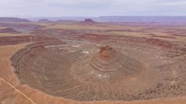 San Juan Kanyonu 'nun havadan görünüşü. Karmaşık katmanlarını ve Meksika Şapkası, Utah yakınlarındaki geniş çöl manzarasını vurguluyor. Çorak arazi ve dolambaçlı toprak yollar dramatik ve engebeli bir manzara sunuyor.