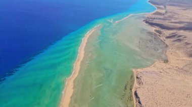Kanarya Adaları 'nda berrak mavi ve turkuaz suların kumlu kıyılarla kurak arazilerin buluştuğu açık mavi ve turkuaz suları gösteren canlı bir kıyı manzarasını gösteren büyüleyici insansız hava aracı görüntüleri..