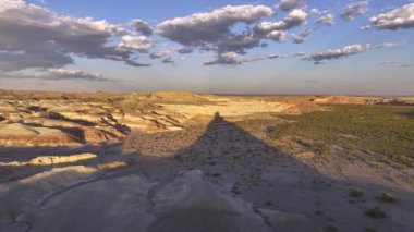 Bir insansız hava aracı tarafından çekilen hava görüntüsü Hanksville, Utah, ABD 'de günbatımında muazzam bir gökyüzü altında dinamik bulut oluşumlarıyla görkemli bir kaya oluşumunu gösteriyor..