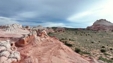 Bu çarpıcı görüntü, Arizona, ABD 'deki White Pocket' daki gerçek üstü jeolojik oluşumları, engebeli bir çöl ortasındaki zengin dokuları ve canlı toprak tonlarını gözler önüne seriyor.