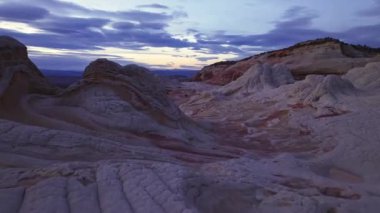 Alacakaranlık, Arizona, White Pocket 'daki eşsiz, girdaplı kaya oluşumlarına doğal desenleri ve ince renk değişimlerini gösteren dingin bir ışıltı yayar.