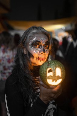 Yetişkin bir İspanyol kadın Ölüler Günü kutlaması sırasında su kabağıyla poz veriyor. Meksika 'da geleneksel Dia de Muertos kavramı