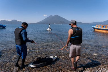 İspanyol gençler, yaklaşan su macerası için bir su kayağı tahtası hazırlıyor.