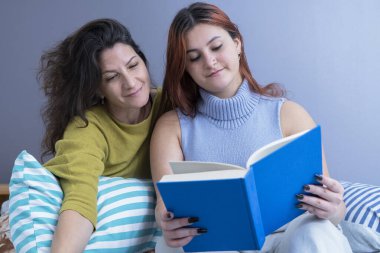 Anne ve kızının rahat bir evde kitap okuduğu huzurlu bir an..
