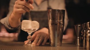 Bir barmen bardağı buzla soğutur, bir Cosmopolitan ya da başka bir klasik içeceğe hazırlar paslanmaz çelik karıştırıcı ve bar aletleri profesyonel ve sofistike bir ortam yaratır.