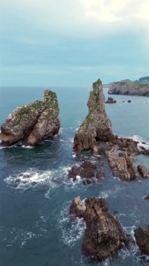 İspanya 'nın Asturias kentindeki nefes kesici uçurumları keşfedin, bu gerçek zamanlı videoda dramatik kaya oluşumları ve canlı deniz manzaraları gösterilmektedir..
