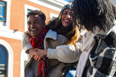 Mutlu çoklu etnik arkadaşlar kışın Avrupa 'nın bir şehrinde gezintiye çıkıyorlar.