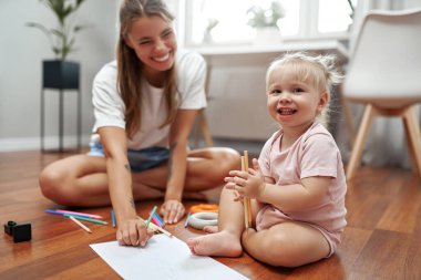 Bir anne ve çocuğu, sanatsal yaratıcılığı artırmak ve sıcak, neşeli bir ortamda aralarındaki bağı güçlendirmek, öğrenmeyi, hayal gücünü ve bağlantıyı geliştirmek için evde yaratıcı bir sanat etkinliğinin tadını çıkarırlar.