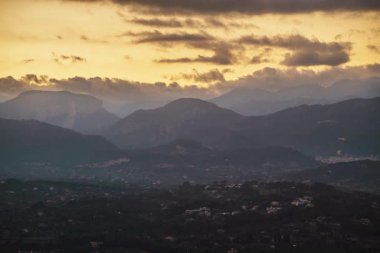 Nefes kesen bir zaman atlaması, Mallorcas 'ın yuvarlanan dağlarında güneşin batışını yakalayarak bulutların ve vadilerin üzerine altın bir parıltı saçar. Gün ışığından alacakaranlığa geçiş huzurlu bir atmosfer yaratır..