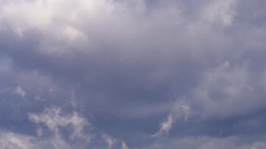 Zaman atlaması, mavi gökyüzünde yuvarlanan kara bulutların hareketlerini yakalıyor. Havayla ilgili içerik, doğa geçmişi ya da atmosferik değişim görselleri için mükemmel..