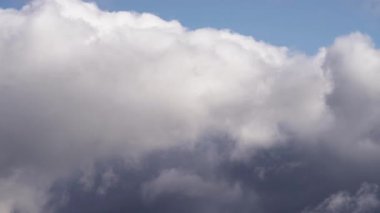 Yoğun, tüylü bulutların zaman atlaması mavi bir gökyüzünde hareket ederek ışık değiştikçe daha koyu tonlara dönüşüyor. Dinamik hava ve bulut oluşumunun çarpıcı bir görüntüsü
