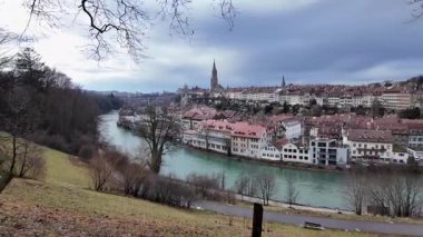 Kentin tarihi mimarisinin yer aldığı İsviçre 'nin Bern kentinin manzaralı kış manzarası. Aare Nehri bulutlu bir gökyüzünün altında akar, çıplak ağaçlarla birlikte bir kış tılsımı eklenir..