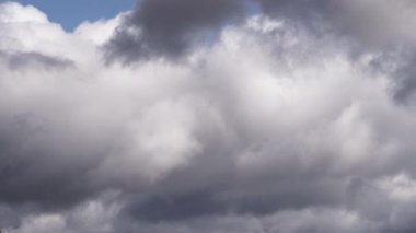 Çarpıcı bir zaman dilimi kara bulutları yakalıyor gökyüzünde yuvarlanıyor ve kaynaşıyor, yumuşak bir ışık yarılıyor. Bulut hareketi hüzünlü ama barışçıl bir geçiş sunuyor. Mavi ipuçları veriyor..