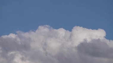 Bu zaman ayarlı video, kümülüs bulutlarının parlak mavi gökyüzüne karşı büyüleyici hareketini yakalar ve atmosferin dinamik güzelliğini gerçek zamanlı olarak gösterir..