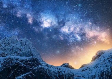 Güzel dağların üzerinde parlayan Samanyolu kışın karla kaplı tepe noktasında parlak yıldızlı gökyüzü ile Samanyolu, karlı kayalar, tepeler, altın ışık. Boşluk. Doğa