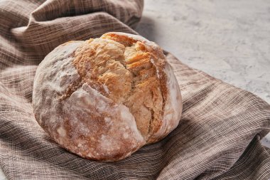 Masadaki peçeteye konmuş taze ekmek somununun üstünden.