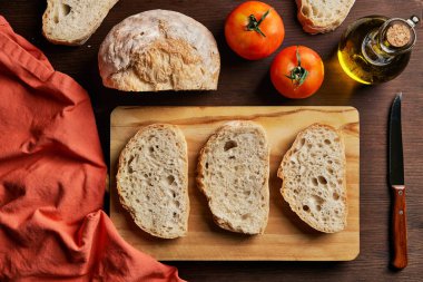 Masada zeytin yağı ve bruschetta pişirmek için hazırlanmış olgun domateslerle hazırlanmış taze ekmek dilimlerinden.