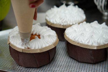 Pasta atölyesinde pasta süsleyen bir kadın.