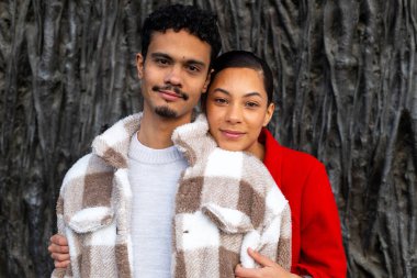 Mutlu çoklu etnik çiftler birbirlerine sarılıyorlar, doğal ortamda romantik bir anın tadını çıkarıyorlar.