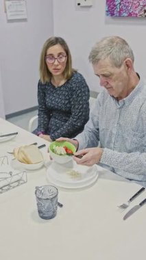 Entellektüel engelli bir erkek öğle yemeğini masada hazırlarken, bir kadın gözetim altında bir apartman dairesinde yaşam becerilerini, bağımsızlığını ve sağlıklı rutinlerini gözlüyor.