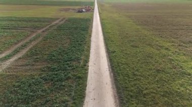 İnsansız hava aracı görüntüleri, Cenevre 'nin kırsal bölgelerinde tarımsal yaşamı ve manzaranın güzelliğini ön plana çıkaran uzun toprak bir yol ve ekili tarlalarla geniş tarım arazileri gösteriyor..