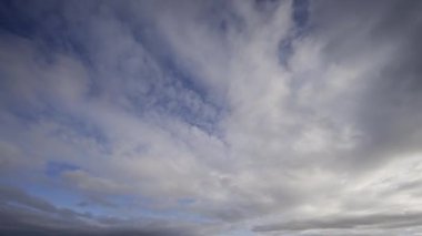 Mavi gökyüzünün büyüleyici geçişi ve yüzen bulutlar çarpıcı bir zaman atlamalı videoda. Huzurlu güzellik ve doğanın dinamik değişimleri.
