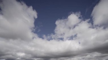 Çarpıcı bir zaman dilimi videosu, beyaz kümülüs bulutlarının derin mavi gökyüzünde hızla hareket ederek atmosferik koşulların güzelliğini ve geçiciliğini gözler önüne seriyor..