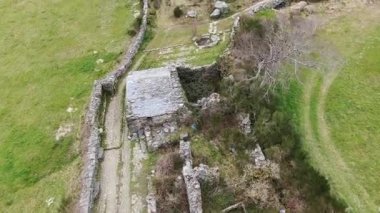 Antik taş yolların ve yıpranmış harabelerin havadan görünüşü yeşil kırsal bir araziye yerleşmiş, tarihle doğa arasındaki uyumu gösteriyor..