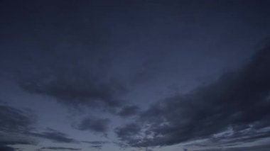 Büyüleyici bir zaman kayması videosu gece gökyüzünün altında dönen karanlık bulutların dinamik hareketlerini gösteriyor. Doğanın hareketli saf güzelliğini ve akışkanlığını ortaya çıkarıyor..