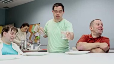 Zihinsel engelli yetişkinlerden oluşan bir grup günlük yaşam becerilerine sahiptir. Bağımsızlık, işbirliği ve sorumluluğu desteklemek için bir günlük merkezde masayı bir araya getirirler.