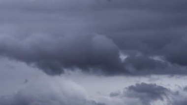 Gökyüzünde biriken karanlık ve uğursuz fırtına bulutlarının dinamik hareketlerini gösteren büyüleyici bir zaman dilimi videosu yaklaşan fırtınanın canlı bir tasvirini sunuyor..