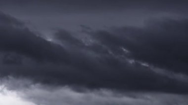 Gökyüzünde biriken karanlık ve uğursuz fırtına bulutlarının dinamik hareketlerini gösteren büyüleyici bir zaman dilimi videosu yaklaşan fırtınanın canlı bir tasvirini sunuyor..