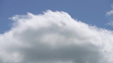 Hızlı hareket eden ve evrimleşen beyaz bulutları mavi gökyüzüne karşı yakalayan zaman dilimi videosu hareket halindeki havanın dinamiğini vurguluyor..