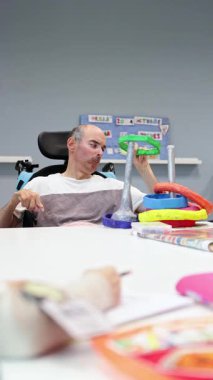 Gündüz merkezindeki bir katılımcı zihinsel engelliler için tasarlanmış etkinliklere odaklanır, destekleyici bir ortamda öğrenmeyi ve sosyal etkileşimi teşvik eder.