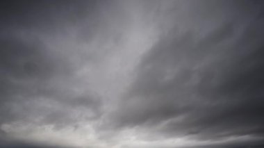 Karanlık, uğursuz bir gökyüzünde toplanan şiddetli fırtına bulutlarının dinamik hareketlerini ve değişen örüntülerini gösteren canlı bir zaman dilimi videosu..