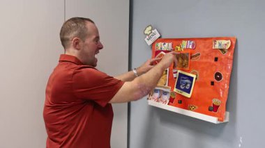 Zihinsel engelli bir yetişkin, yemek seçmek, özerklik ve günlük yaşam becerilerini geliştirmek için resimleri kullanarak, bir günlük merkezde bir yemek menüsü planlama işine girişir..