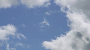Bulutların hızlı ve dinamik hareketlerini gösteren bir zaman dilimi videosu canlı mavi gökyüzünde, doğanın dingin ama güçlü görüntüsünü yakalıyor..
