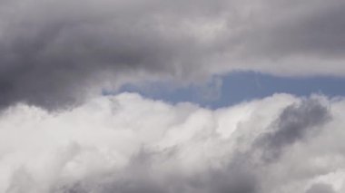 Bu zaman ayarlı video, karanlık fırtına bulutlarının dramatik bir araya gelişini, hava değişirken dinamik ve karamsar atmosferi yansıtıyor..