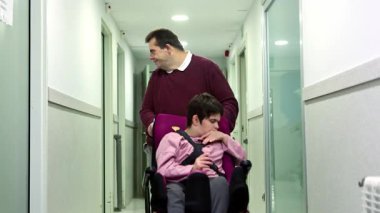 Bir akıl hastanesinde, engelli bir adam tekerlekli sandalyedeki engelli bir kadına koridorda yol gösterirken yardım ederken yakalandı. Bu gerçek zamanlı fotoğrafta özen ve ilgi gösteriyor. Desteği ve empatiyi somutlaştırıyor..