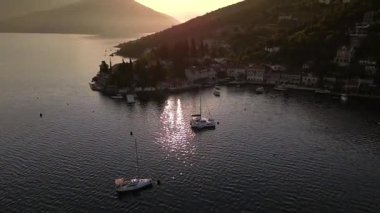 Gün batımında Karadağ 'ın büyüleyici kıyı şeridini deneyimleyerek, yumuşak altın ışığa batmış sakin Adriyatik Denizi, geleneksel mimari ve yemyeşil yamaçları sergiliyor..