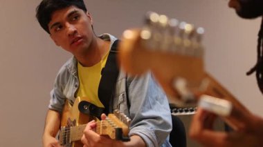 İki müzisyen bir kayıt stüdyosunda yaratıcı bir oturum sırasında yakalanır. Profesyonel ses ekipmanlarıyla çevrelenmiş, dikkatle müziklerine odaklanan elektro gitarlar çalıyorlar..