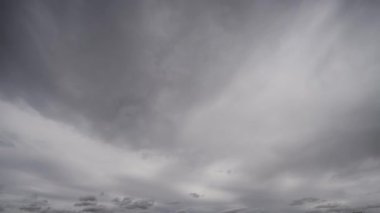 Gökyüzünde yoğun, karanlık fırtına bulutlarının dramatik ve hızlı bir şekilde toplandığını gösteren bir zaman kaydıyla yaklaşan fırtınayı gösteriyor..