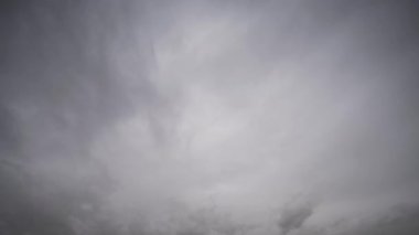 Gri fırtına bulutlarının gökyüzünde dinamik bir şekilde toplanıp hareket ettiğini ve fırtınadan önceki havayı yakaladığını gösteren bir zaman dilimi videosu..