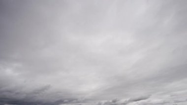 Bu zaman ayarlı video, karanlık fırtına bulutlarının dramatik bir araya gelişini, hava değişirken dinamik ve karamsar atmosferi yansıtıyor..